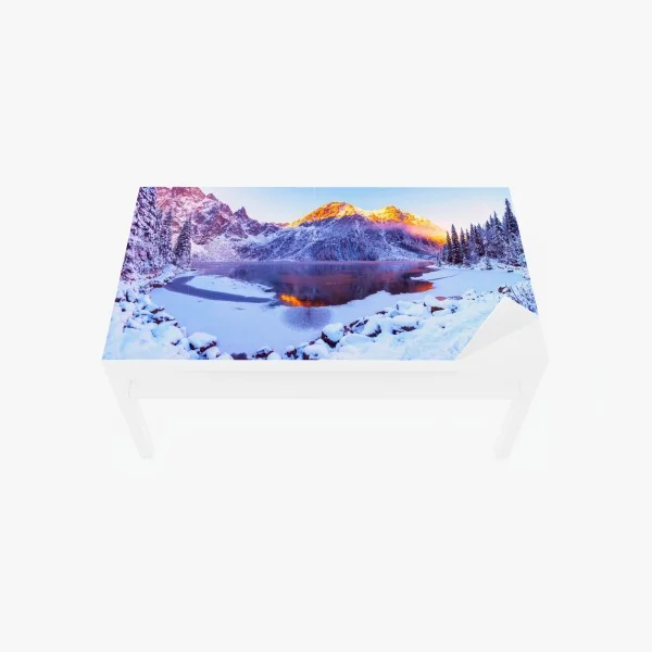 Naklejka na biurko i stół góry skąpane w świetle wschodu nad zamarzniętym jeziorem