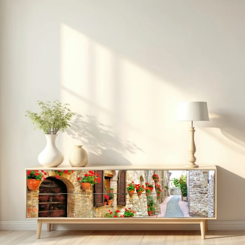 Naklejka repozycjonowalna słoneczna kamienna uliczka z czerwonymi pelargoniami – Wallissimo® Naklejka repozycjonowalna słoneczna kamienna uliczka z czerwonymi pelargoniami – Wallissimo®