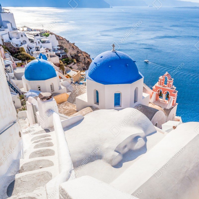 Naklejka na szafę słoneczne Santorini niebieskie kopuły i widok na morze – Wallissimo® Naklejka na szafę słoneczne Santorini niebieskie kopuły i widok na morze – Wallissimo®