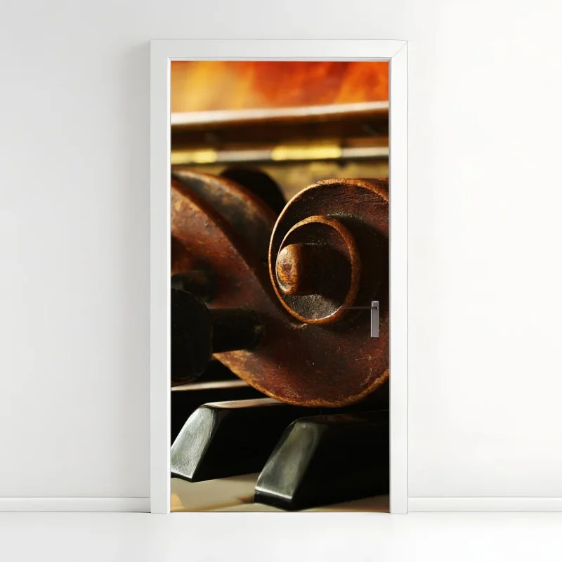 Naklejka na drzwi zabytkowa główka skrzypiec na klawiszach fortepianu