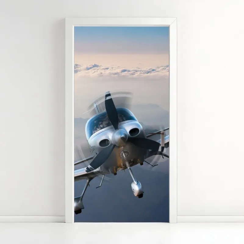 Naklejka na drzwi srebrny samolot śmigłowy nad mglistymi górami