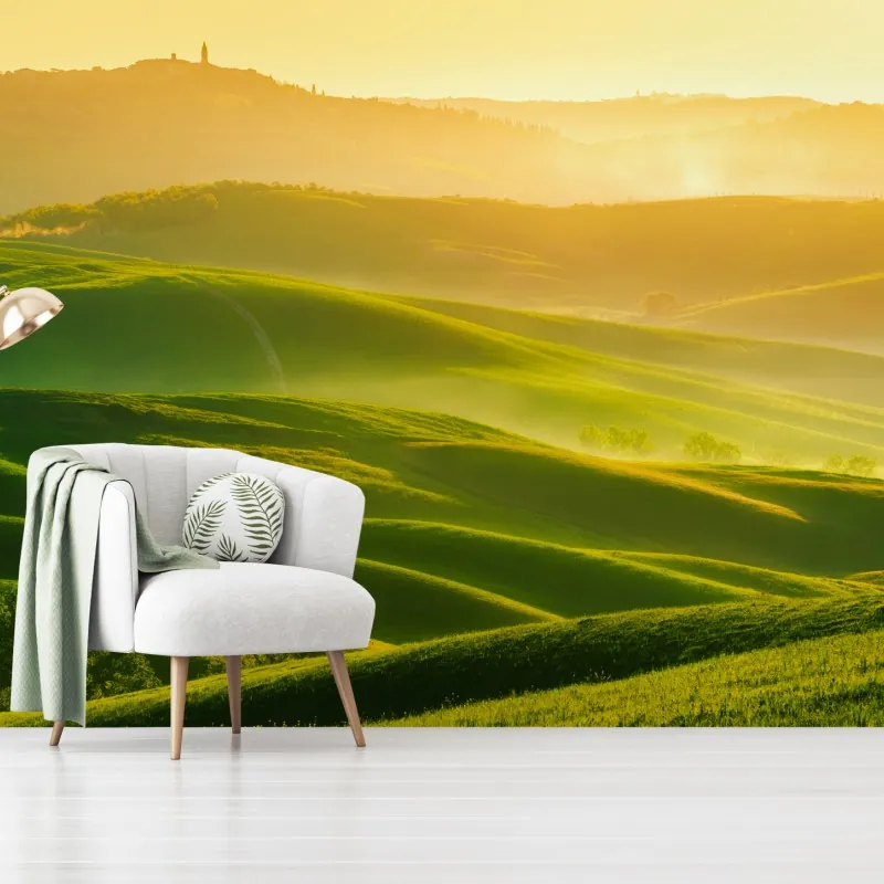 Fototapeta złoty wschód słońca nad zielonymi falującymi wzgórzami