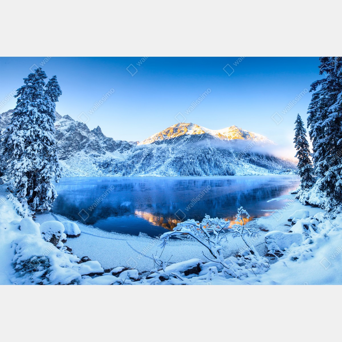Naklejka repozycjonowalna zimowy wschód słońca nad zamarzniętym górskim jeziorem – Wallissimo® Naklejka repozycjonowalna zimowy wschód słońca nad zamarzniętym górskim jeziorem – Wallissimo®