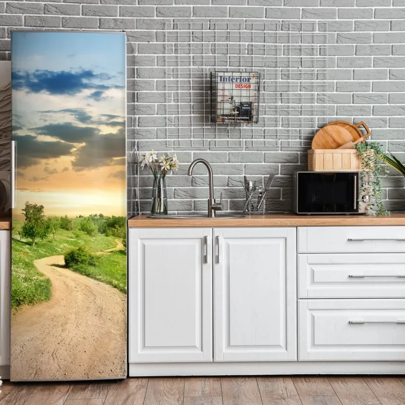 Naklejka na lodówkę zachód słońca nad polną drogą w zielonej łące