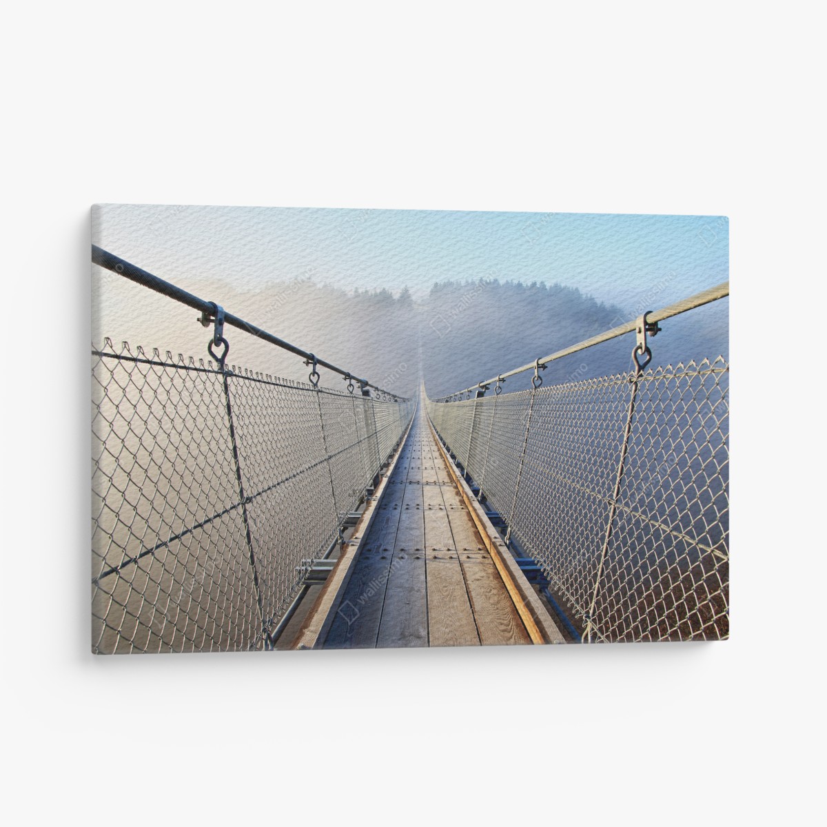 Canvas print foggy suspension bridge leading into the woods
