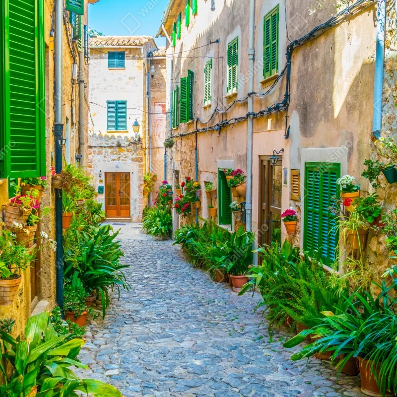 Fototapeta słoneczna uliczka z zielonymi okiennicami – Wallissimo® Fototapeta słoneczna uliczka z zielonymi okiennicami – Wallissimo®