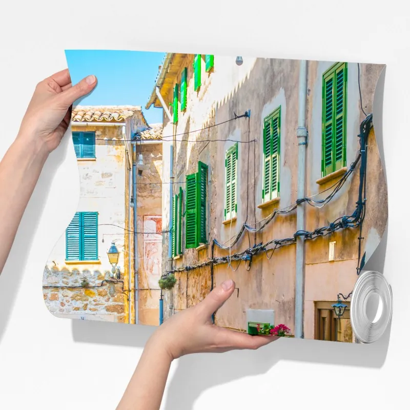 Fototapeta słoneczna uliczka z zielonymi okiennicami – Wallissimo® Fototapeta słoneczna uliczka z zielonymi okiennicami – Wallissimo®