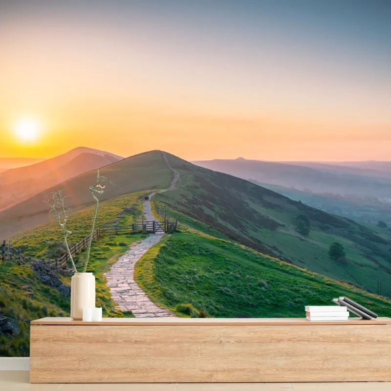 Fototapeta wschód słońca nad zielonymi wzgórzami z kamienną ścieżką