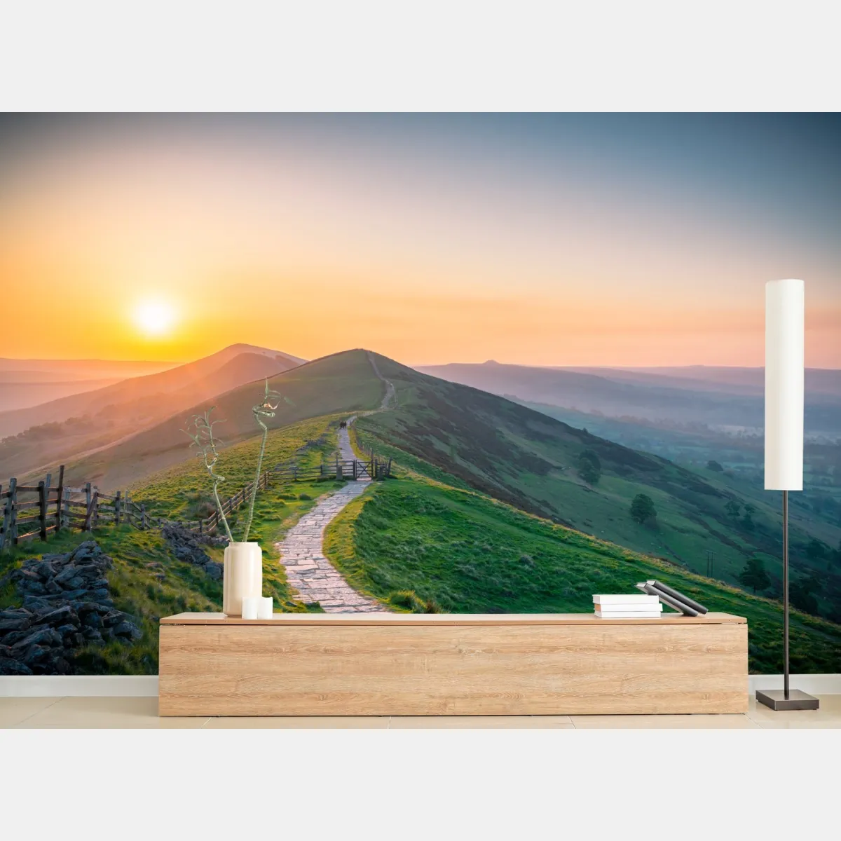 Fototapeta wschód słońca nad zielonymi wzgórzami z kamienną ścieżką – Wallissimo® Fototapeta wschód słońca nad zielonymi wzgórzami z kamienną ścieżką – Wallissimo®