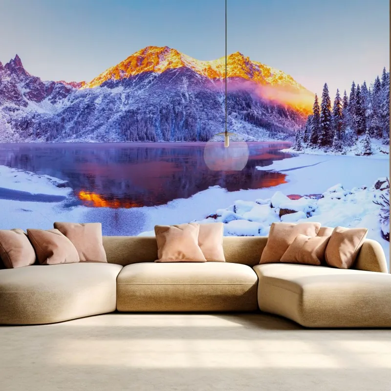 Wall mural sunlit mountains over frozen alpine lake