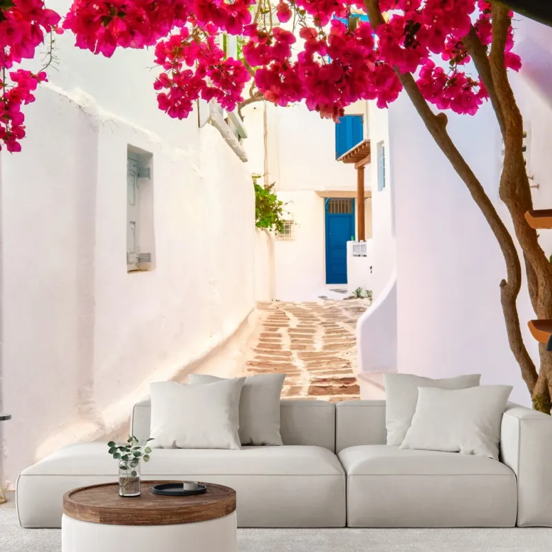 Wall mural sunlit Greek alley with bougainvillea