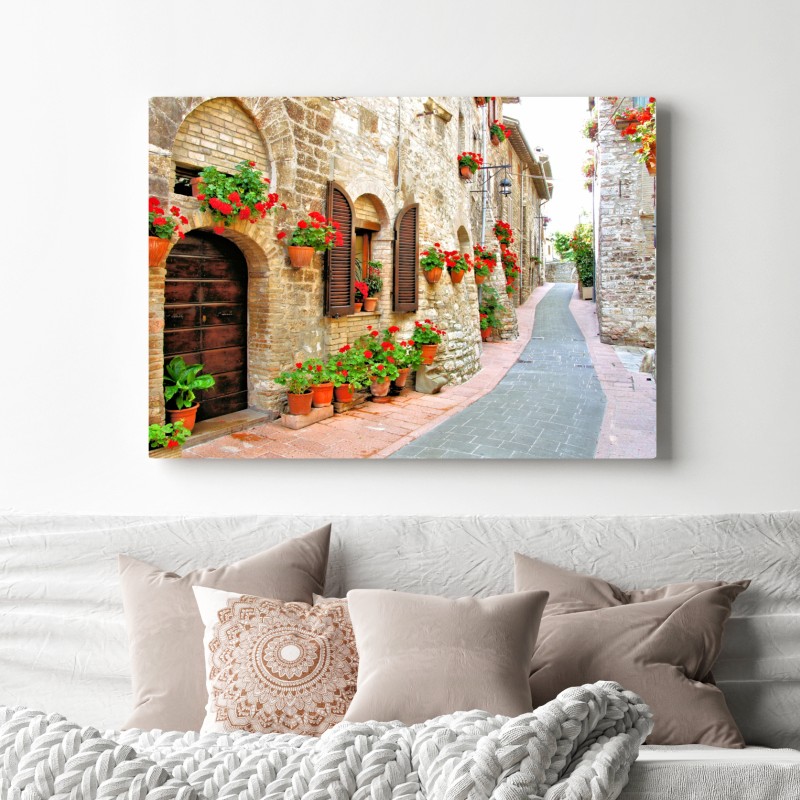 Obraz na płótnie słoneczna kamienna uliczka z czerwonymi pelargoniami – Wallissimo® Obraz na płótnie słoneczna kamienna uliczka z czerwonymi pelargoniami – Wallissimo®